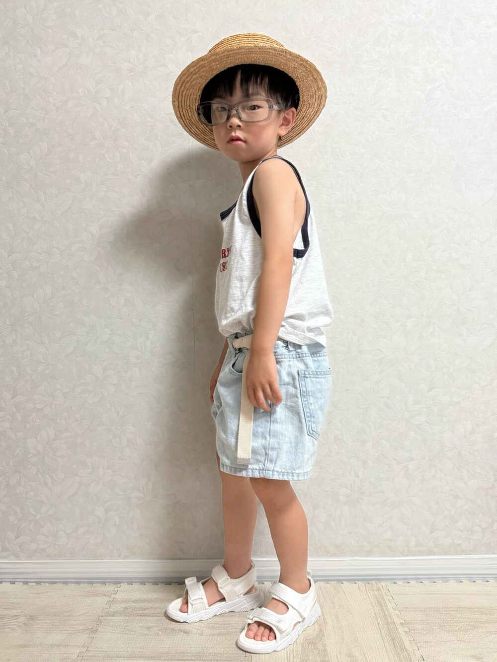 ホワイト系のタンクトップ、ブルー系のデニムパンツ、ホワイト系のサンダルを着用したキッズの夏コーディネートの3枚目の写真