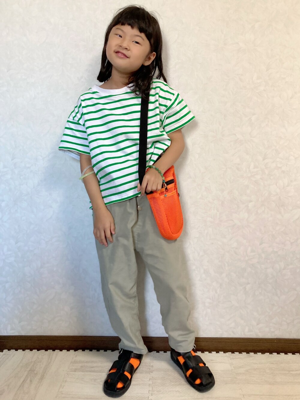 グリーン系のTシャツ/カットソー、グリーン系のパンツ、オレンジ系のショルダーバッグを着用したキッズの夏コーディネートの3枚目の写真