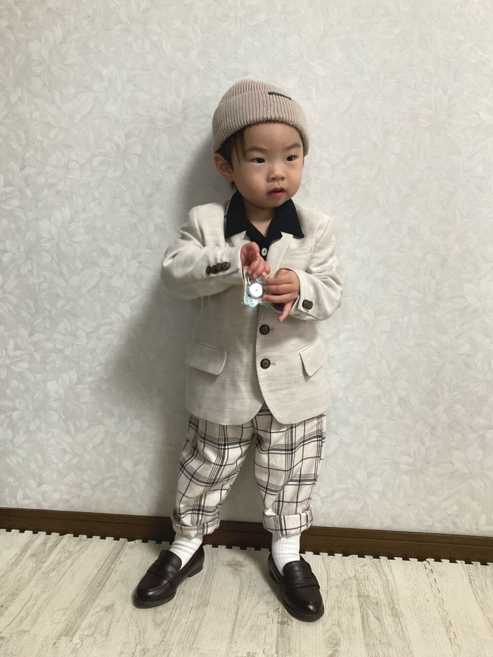 ブラック系のシャツ/ブラウス、ベージュ系のテーラードジャケット、ホワイト系のパンツを着用したキッズの春コーディネートの3枚目の写真