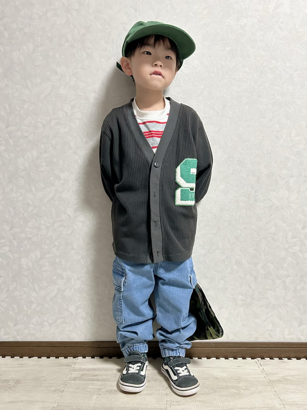 グレー系のTシャツ/カットソー、ブラック系のカーディガン/ボレロ、ブルー系のデニムパンツを着用したキッズの春コーディネートの3枚目の写真
