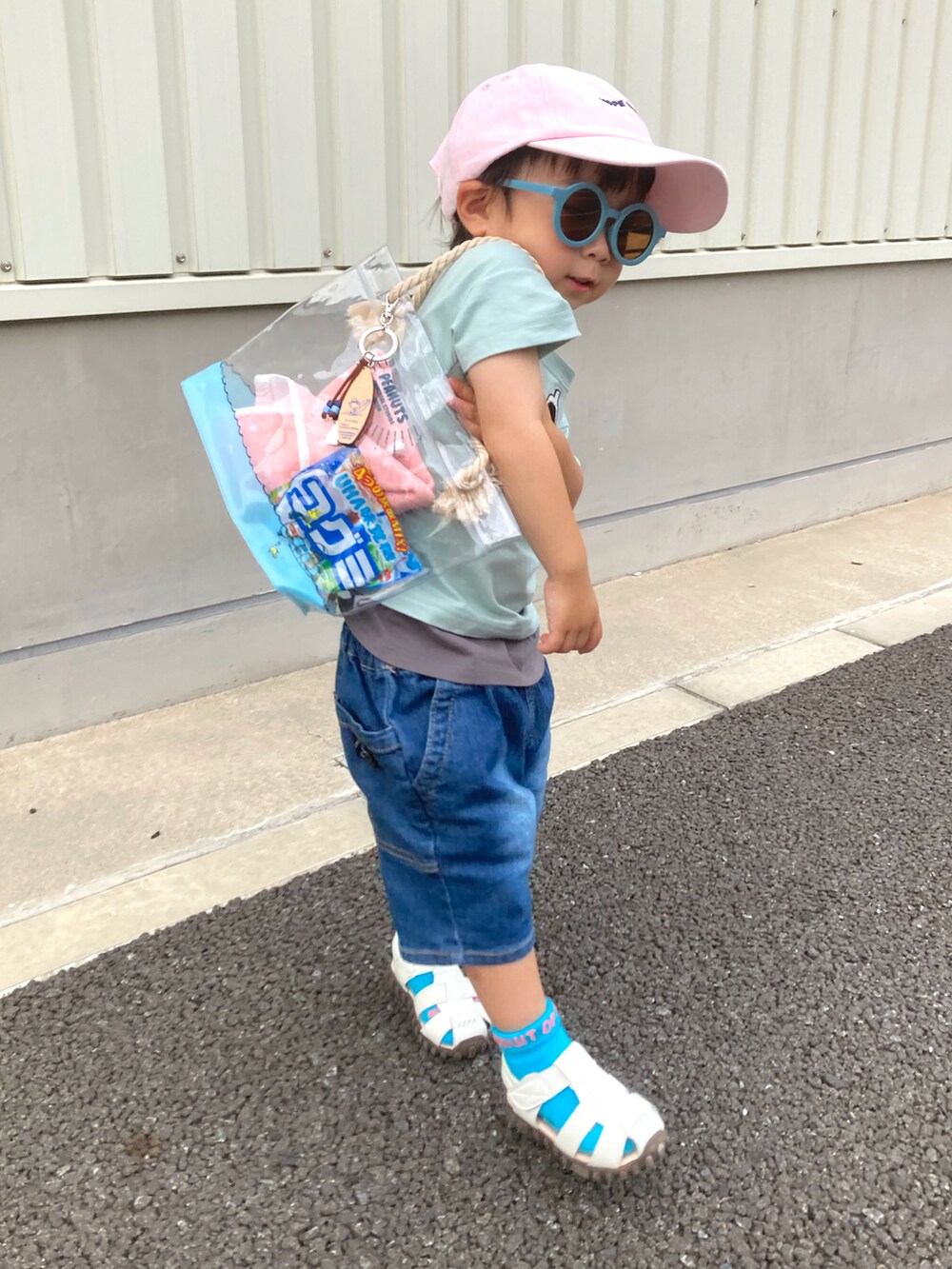 グリーン系のTシャツ/カットソー、ブルー系のデニムパンツ、ホワイト系のサンダルを着用したキッズの夏コーディネートの3枚目の写真