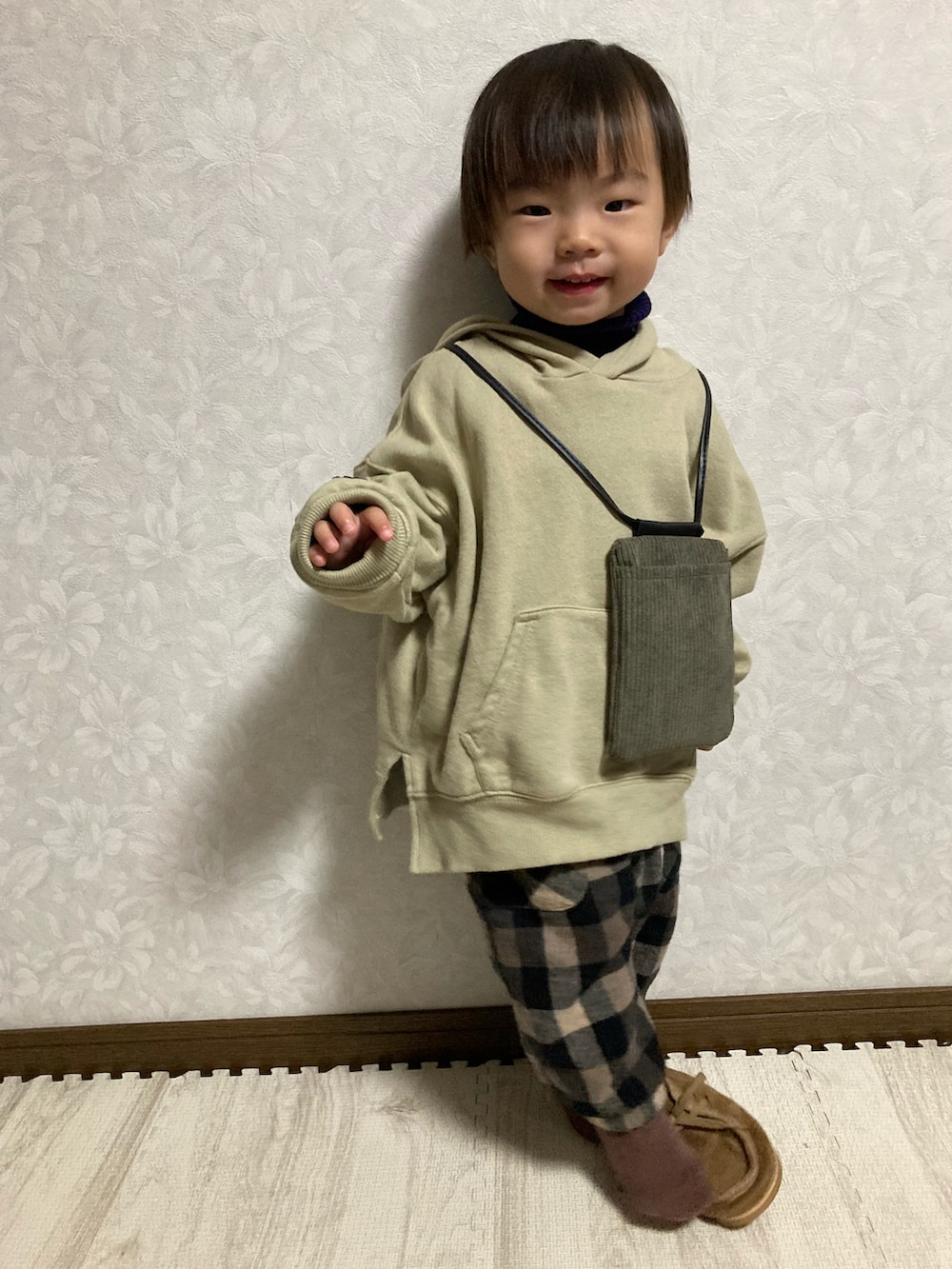ベージュ系のパーカー、グリーン系のバッグ、ブルー系のニット/セーターを着用したキッズの秋コーディネートの2枚目の写真