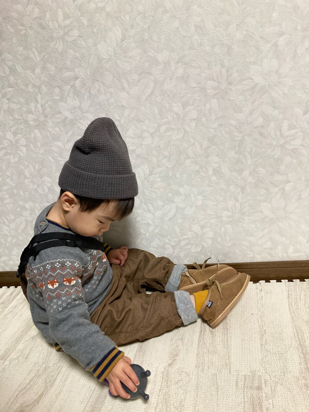 ブラウン系のTシャツ/カットソー、グレー系のニット/セーター、ブラウン系のショルダーバッグを着用したキッズの冬コーディネートの3枚目の写真