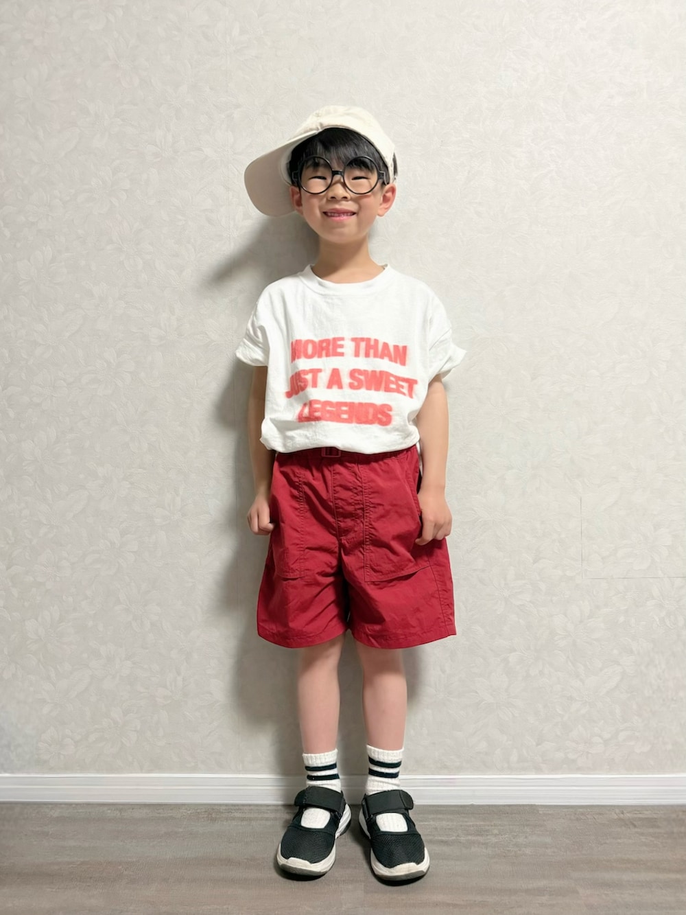 ブラック系のショルダーバッグ、ホワイト系のTシャツ/カットソー、レッド系のパンツを着用したキッズの春コーディネートの2枚目の写真