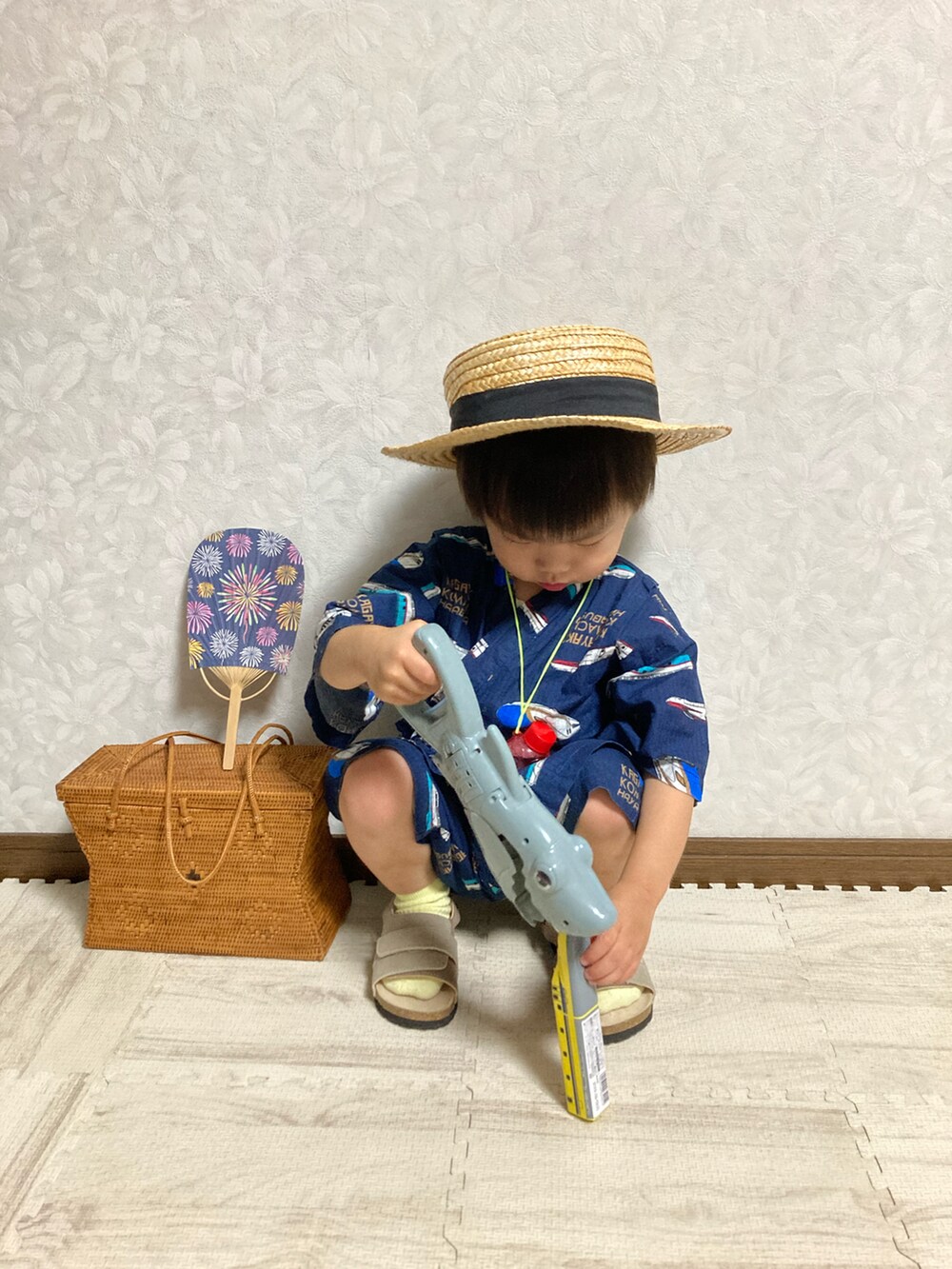 ベージュ系のサンダル、ブラウン系のかごバッグ、ベージュ系のハットを着用したキッズの夏コーディネートの5枚目の写真