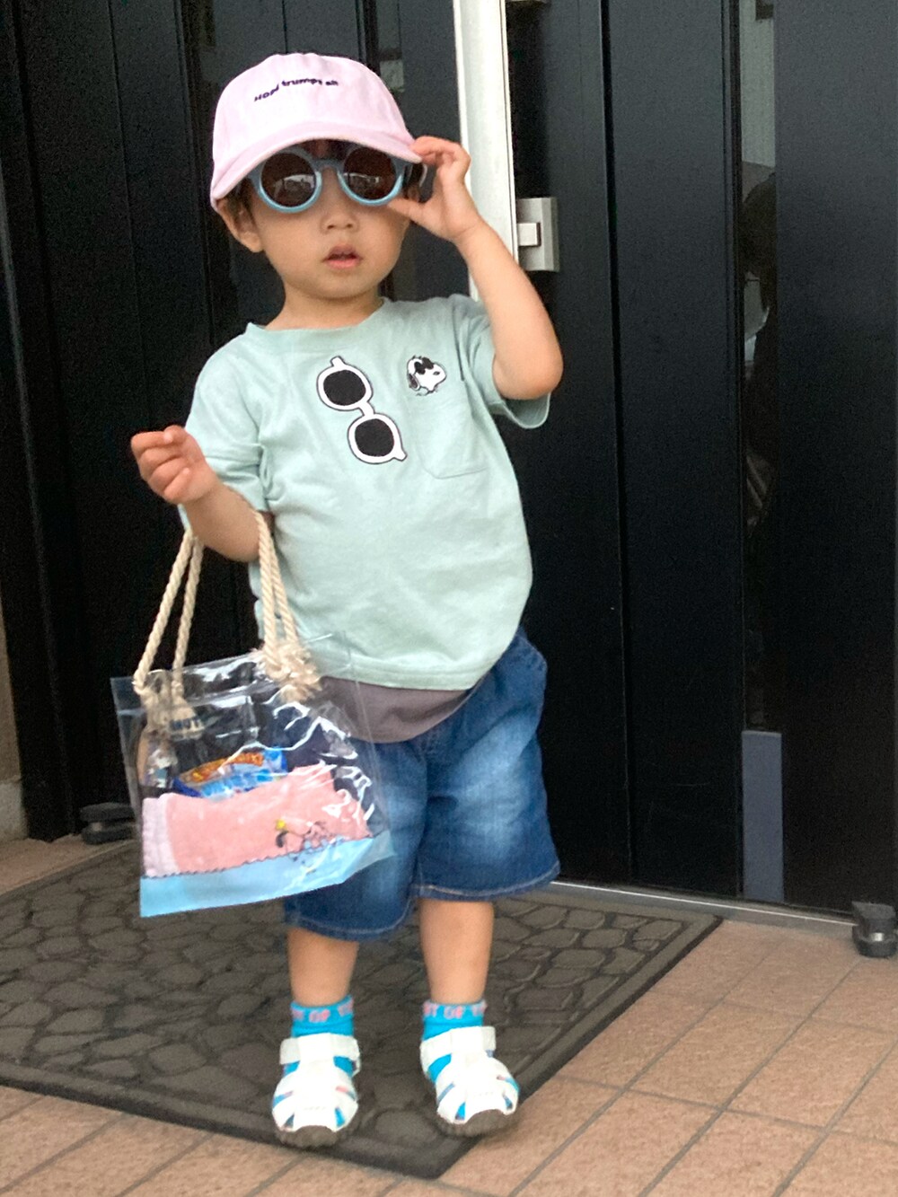 グリーン系のTシャツ/カットソー、ブルー系のデニムパンツ、ホワイト系のサンダルを着用したキッズの夏コーディネートの2枚目の写真