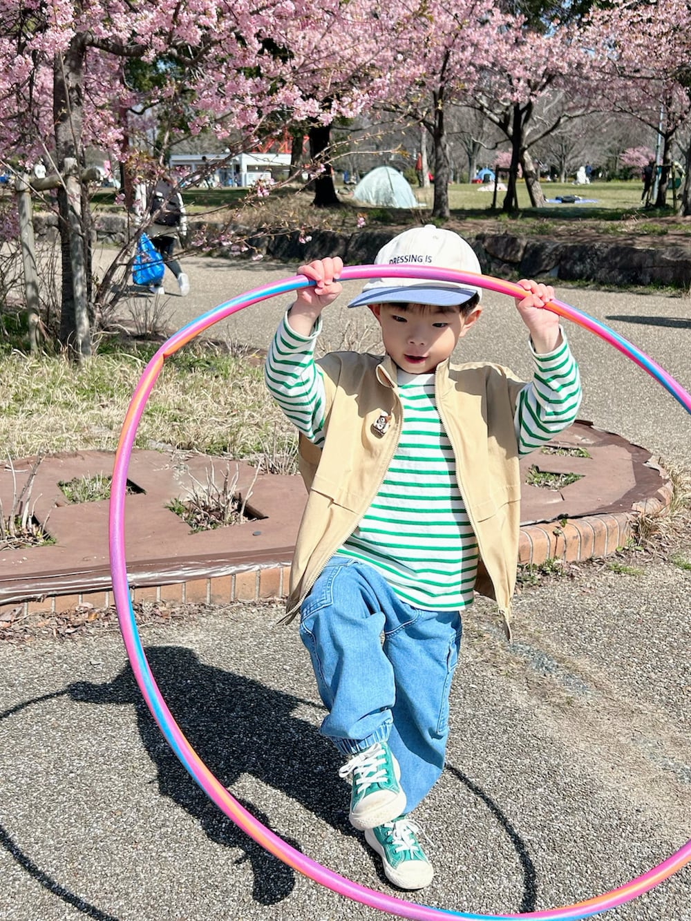 グリーン系のTシャツ/カットソー、ベージュ系のベスト、ブルー系のデニムパンツを着用したキッズの春コーディネートの4枚目の写真