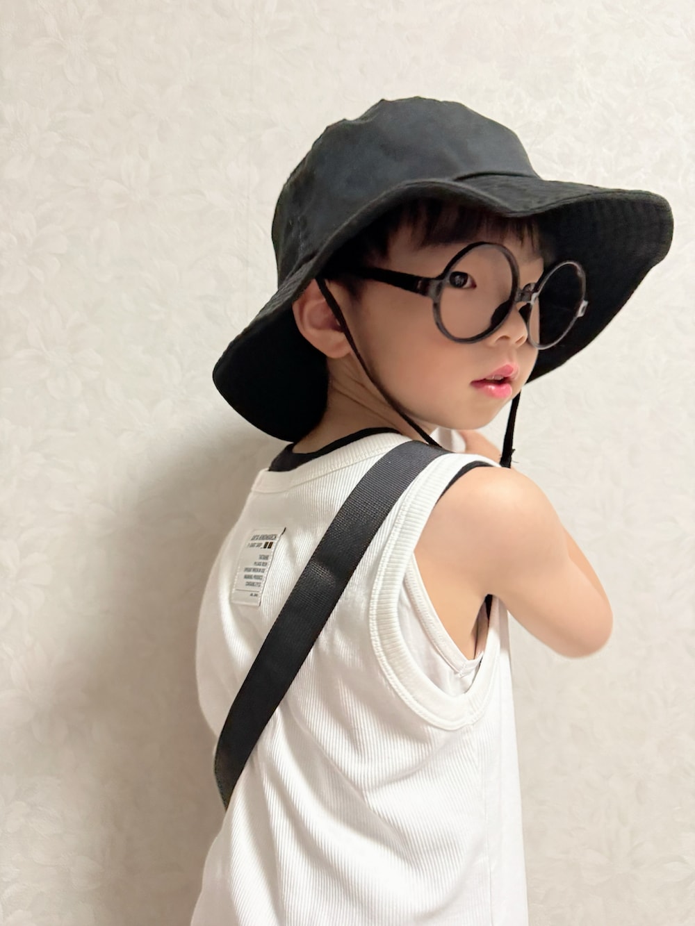 グレー系のパンツ、ブラック系のサンダル、ホワイト系のタンクトップを着用したキッズの夏コーディネートの5枚目の写真