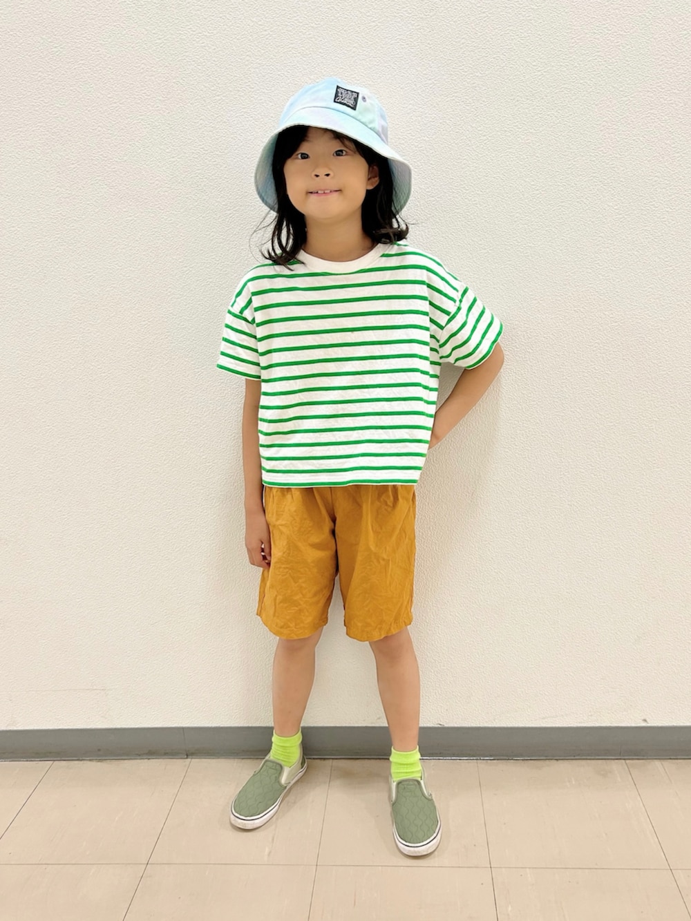 グリーン系のTシャツ/カットソー、イエロー系のその他パンツ、グリーン系のスニーカーを着用したキッズの秋コーディネートの3枚目の写真