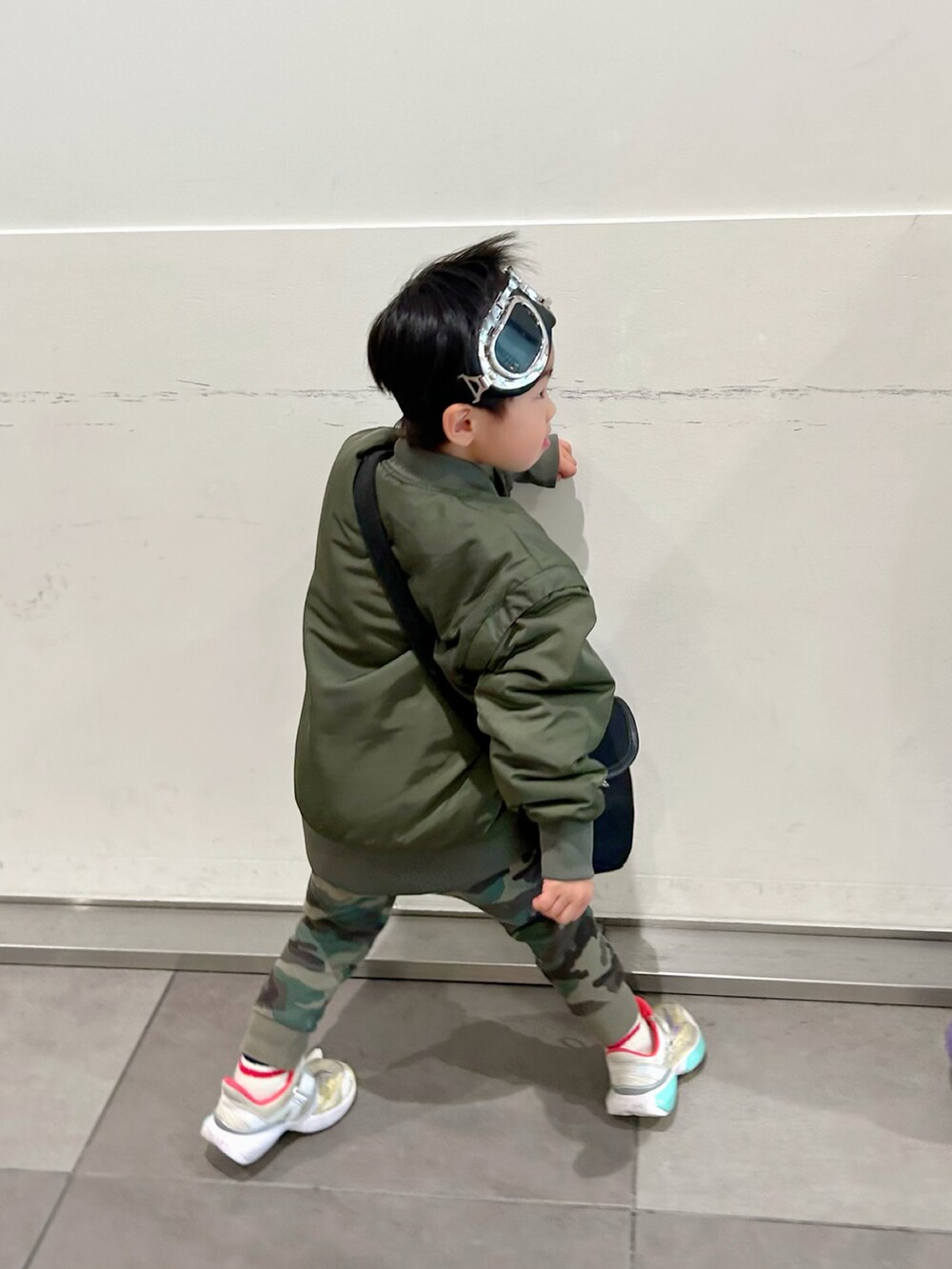 ホワイト系のニット/セーター、ホワイト系のシャツ/ブラウス、ブラック系のショルダーバッグを着用したキッズの冬コーディネートの4枚目の写真