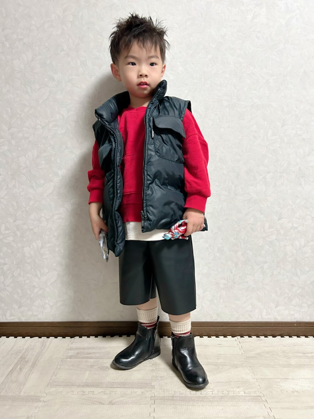 ブラック系のパンツ、レッド系のスウェット、ブラック系のブーツを着用したキッズの冬コーディネートの2枚目の写真