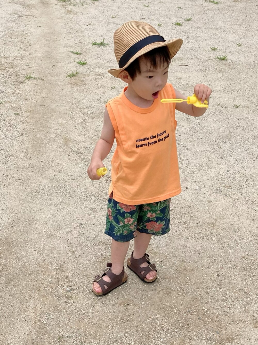 オレンジ系のタンクトップ、ベージュ系のシャツ/ブラウス、ブルー系のパンツを着用したキッズの夏コーディネートの4枚目の写真