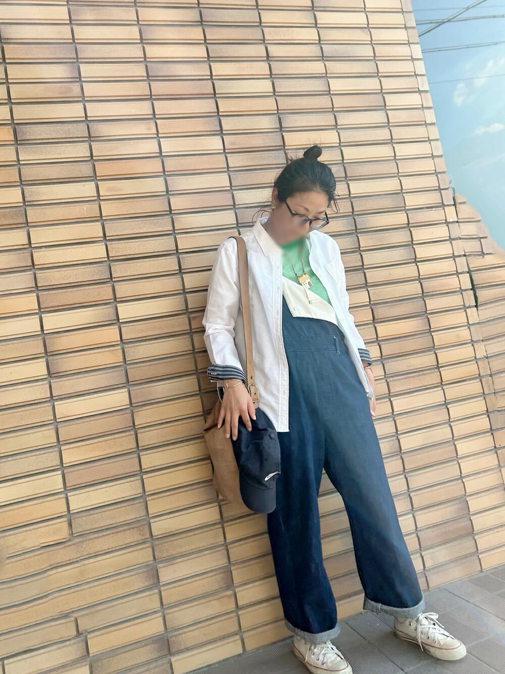 グリーン系のタンクトップ、ブルー系のサロペット/オーバーオール、ホワイト系のスニーカーを着用したレディースの秋コーディネートの4枚目の写真