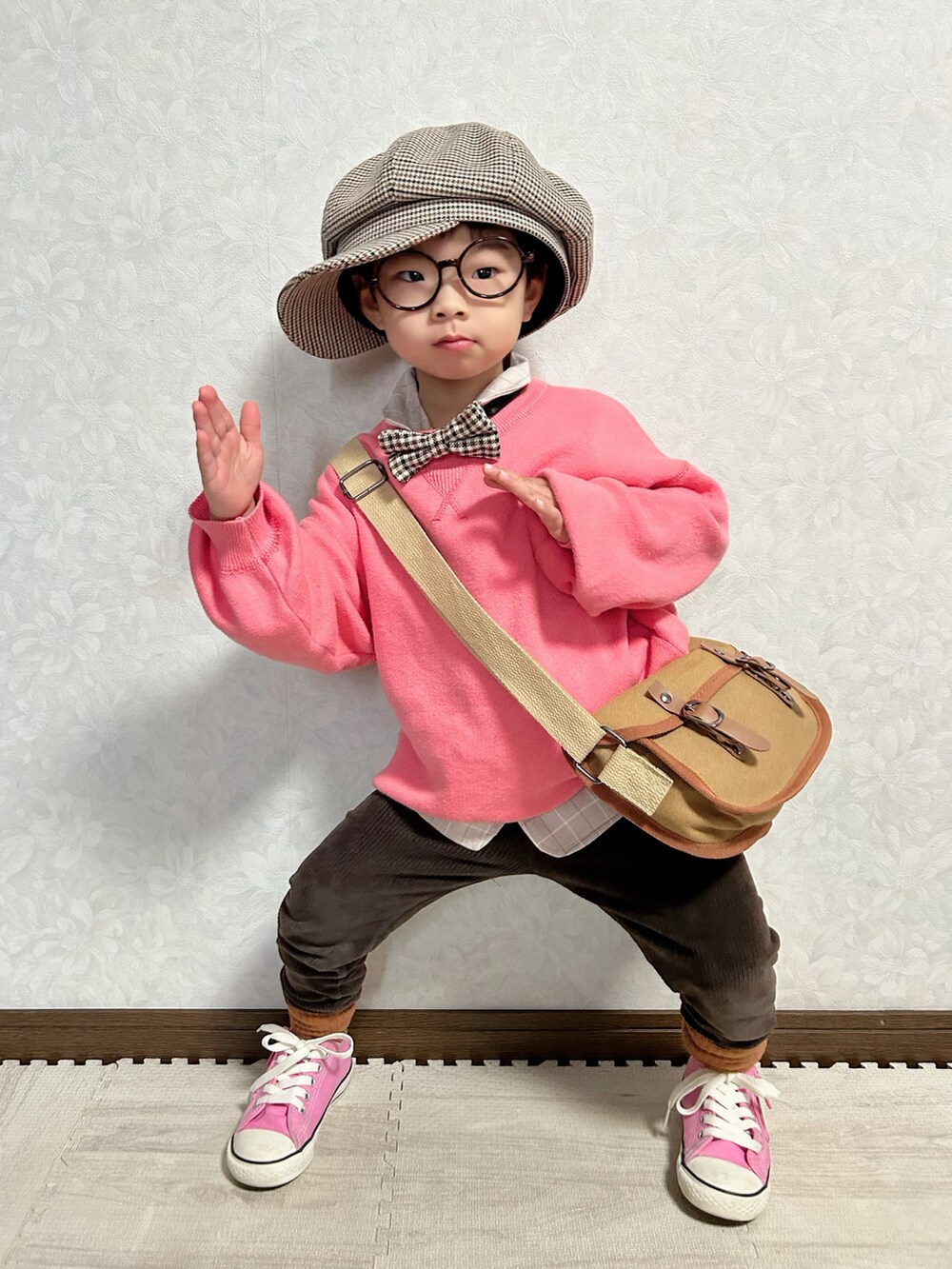 ピンク系のニット/セーター、ベージュ系のセットアップ、ブラウン系のショルダーバッグを着用したキッズの冬コーディネートの3枚目の写真