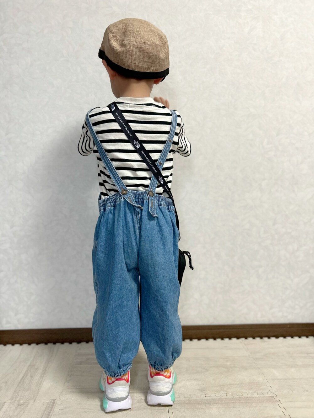 ベージュ系のTシャツ/カットソー、ブルー系のサロペット/オーバーオール、ホワイト系のスニーカーを着用したキッズの秋コーディネートの5枚目の写真