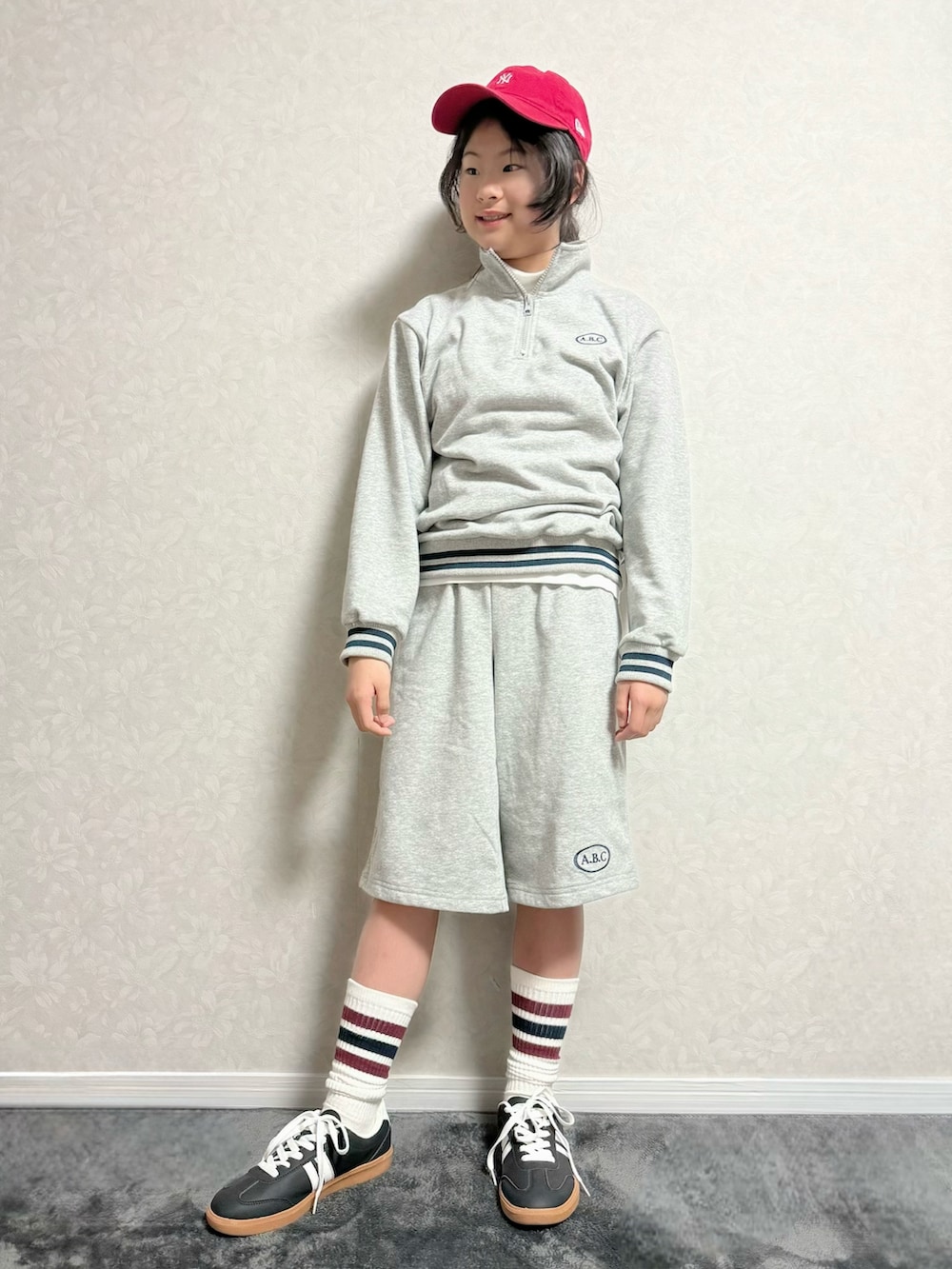 グレー系のセットアップ、ホワイト系のTシャツ/カットソー、ブラック系のトートバッグを着用したキッズの冬コーディネートの2枚目の写真