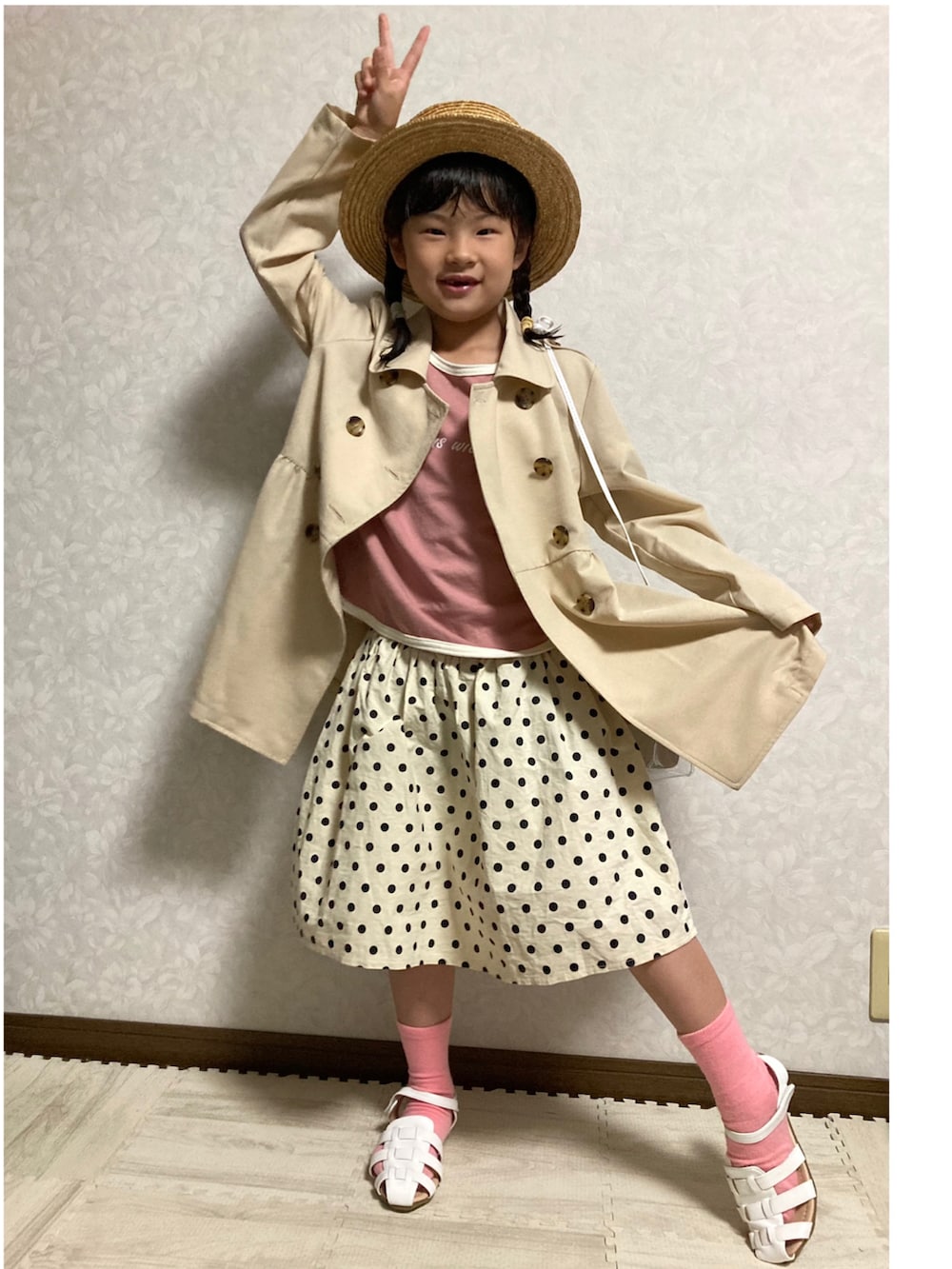 ピンク系のTシャツ/カットソー、ベージュ系のトレンチコート、ホワイト系のショルダーバッグを着用したキッズの春コーディネートの3枚目の写真