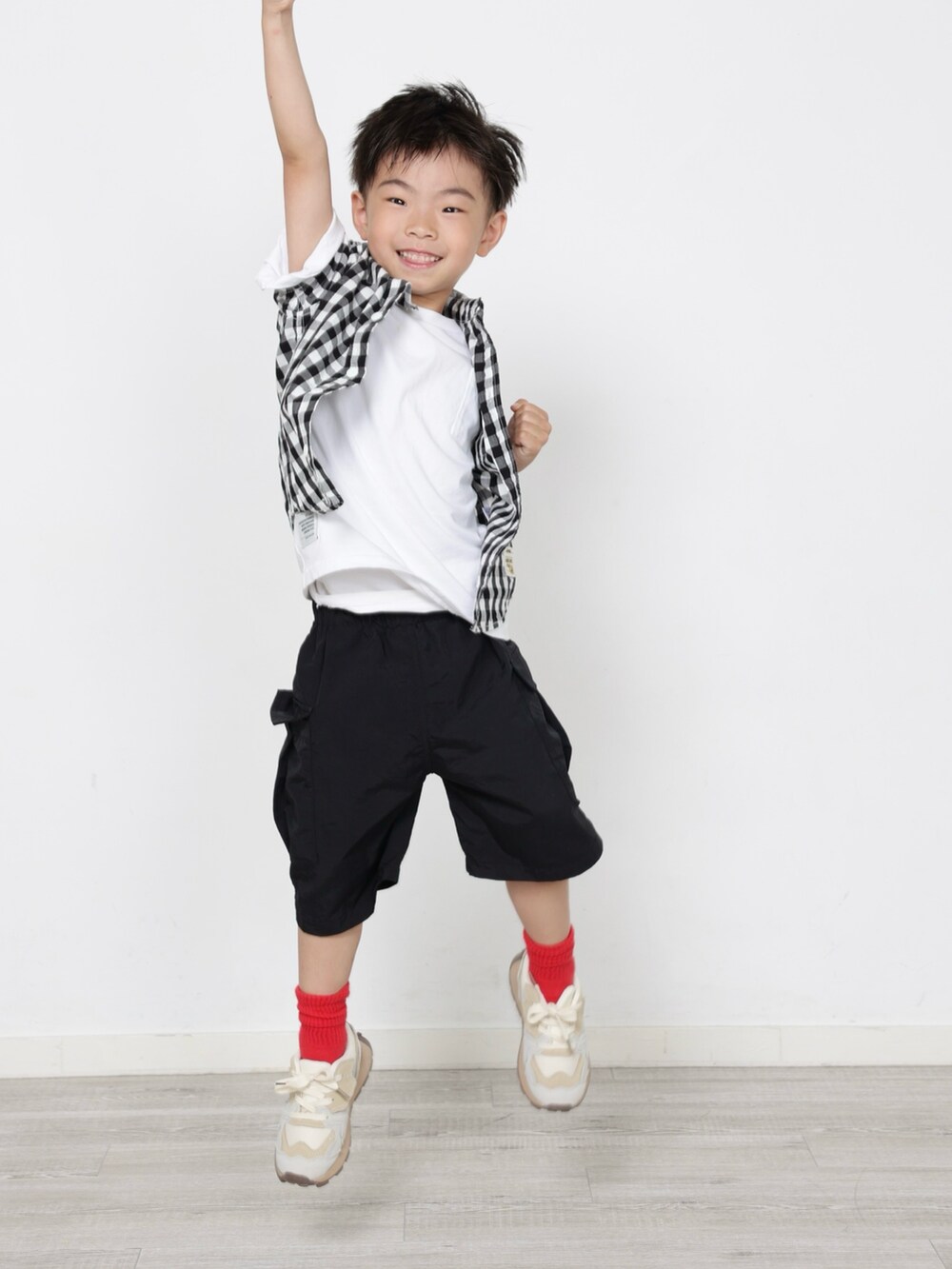 ブラック系のカーゴパンツ、ホワイト系のスニーカー、ブラック系のシャツ/ブラウスを着用したキッズの夏コーディネートの2枚目の写真