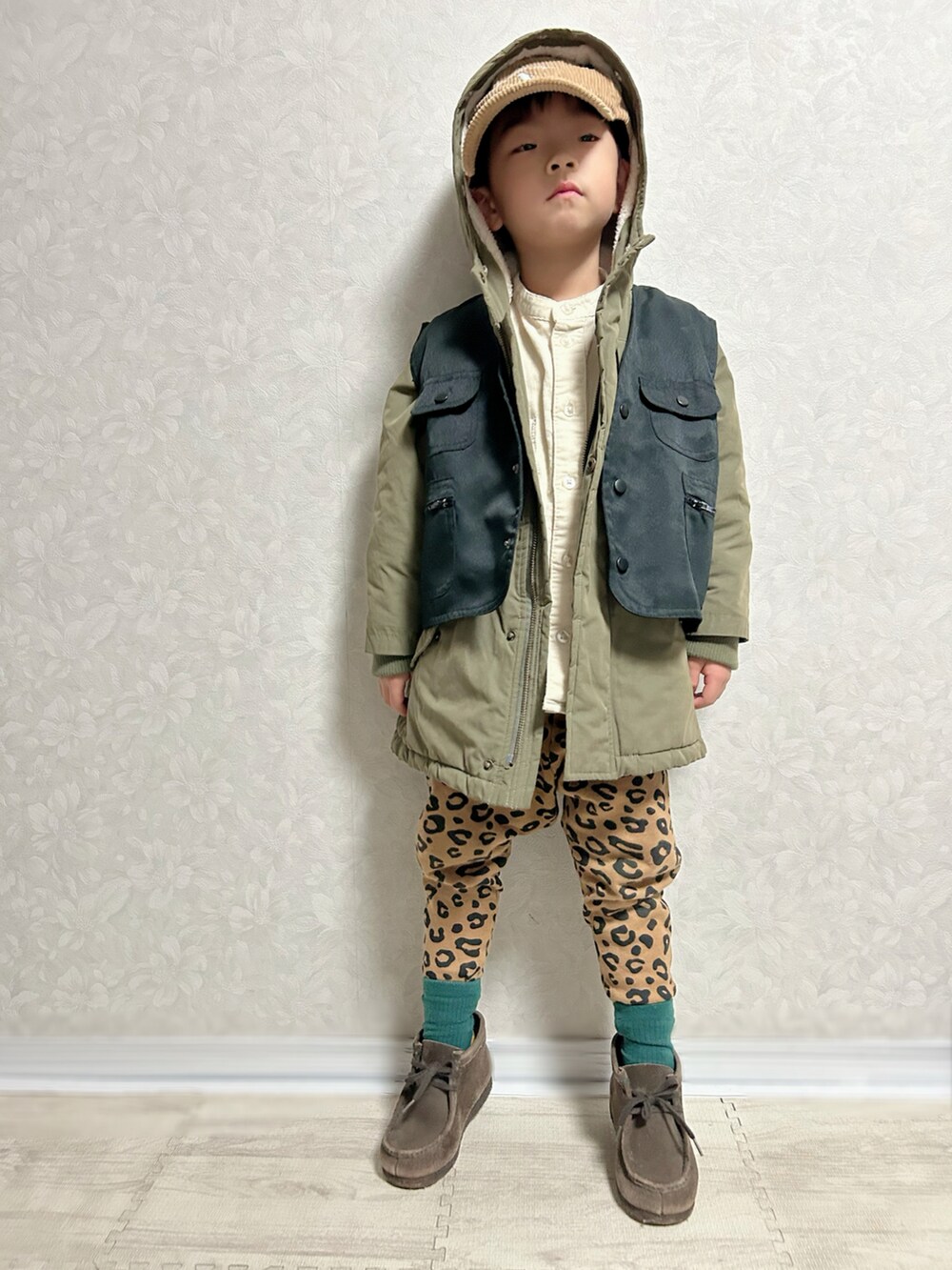 ホワイト系のシャツ/ブラウス、グリーン系のモッズコート、ブラック系のベストを着用したキッズの秋コーディネートの2枚目の写真