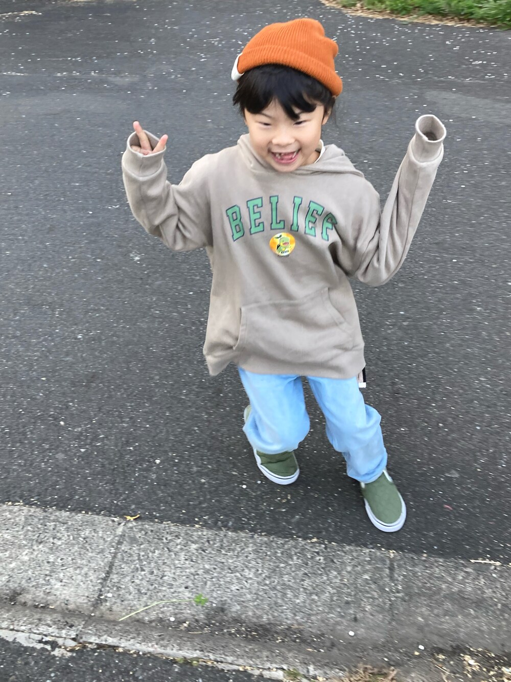 ベージュ系のパーカー、ブルー系のデニムパンツ、グリーン系のスニーカーを着用したキッズの冬コーディネートの3枚目の写真