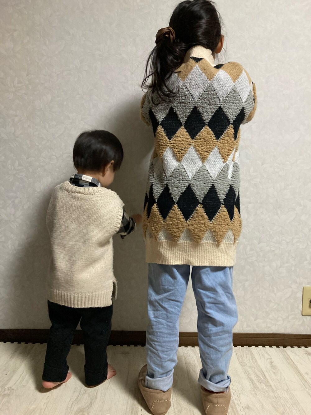 ベージュ系のカーディガン/ボレロ、ホワイト系のTシャツ/カットソー、ブルー系のデニムパンツを着用したキッズの冬コーディネートの5枚目の写真