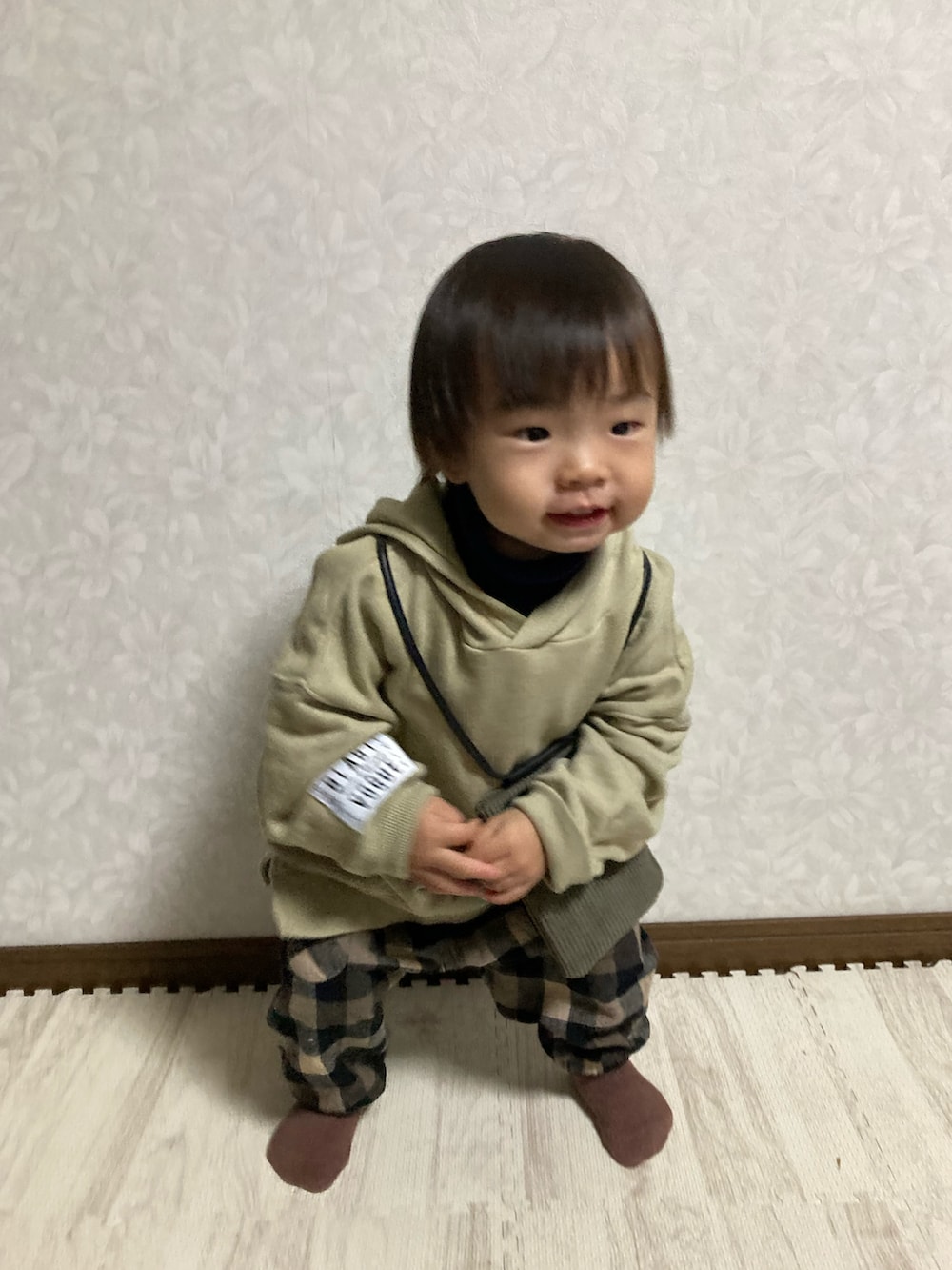 ベージュ系のパーカー、グリーン系のバッグ、ブルー系のニット/セーターを着用したキッズの秋コーディネートの3枚目の写真
