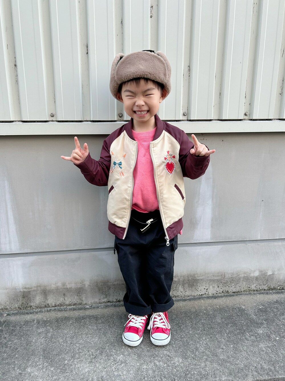 ピンク系のニット/セーター、レッド系のブルゾン、グリーン系のモッズコートを着用したキッズの冬コーディネートの4枚目の写真