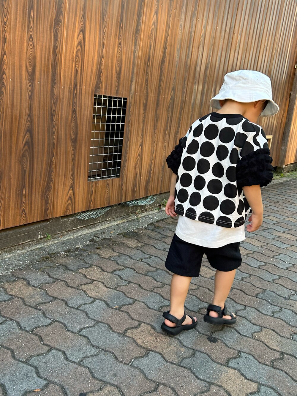 ブラック系のベスト、ブラック系のシャツ/ブラウス、ホワイト系のサンダルを着用したキッズの夏コーディネートの5枚目の写真