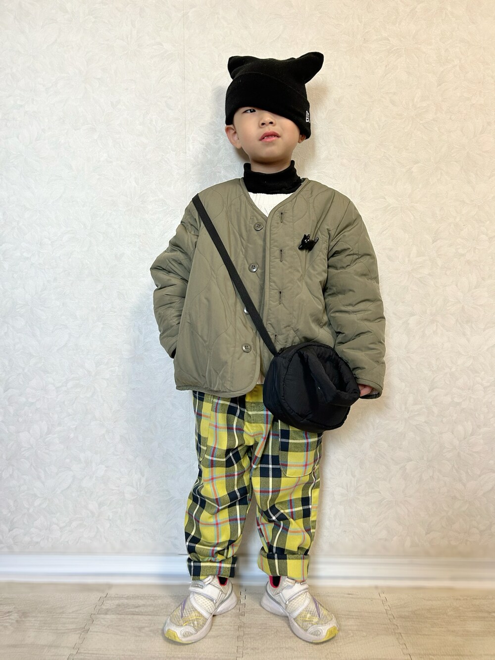 ブラック系のTシャツ/カットソー、ホワイト系のニット/セーター、グリーン系のノーカラージャケットを着用したキッズの冬コーディネートの2枚目の写真