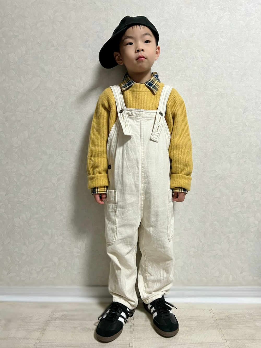 イエロー系のシャツ/ブラウス、イエロー系のニット/セーター、ホワイト系のサロペット/オーバーオールを着用したキッズの冬コーディネートの3枚目の写真
