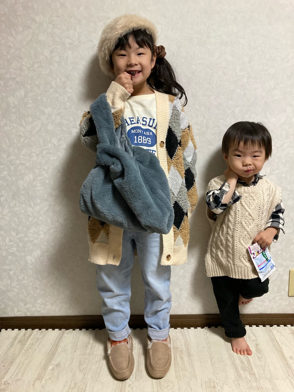 ベージュ系のカーディガン/ボレロ、ホワイト系のTシャツ/カットソー、ブルー系のデニムパンツを着用したキッズの冬コーディネートの4枚目の写真