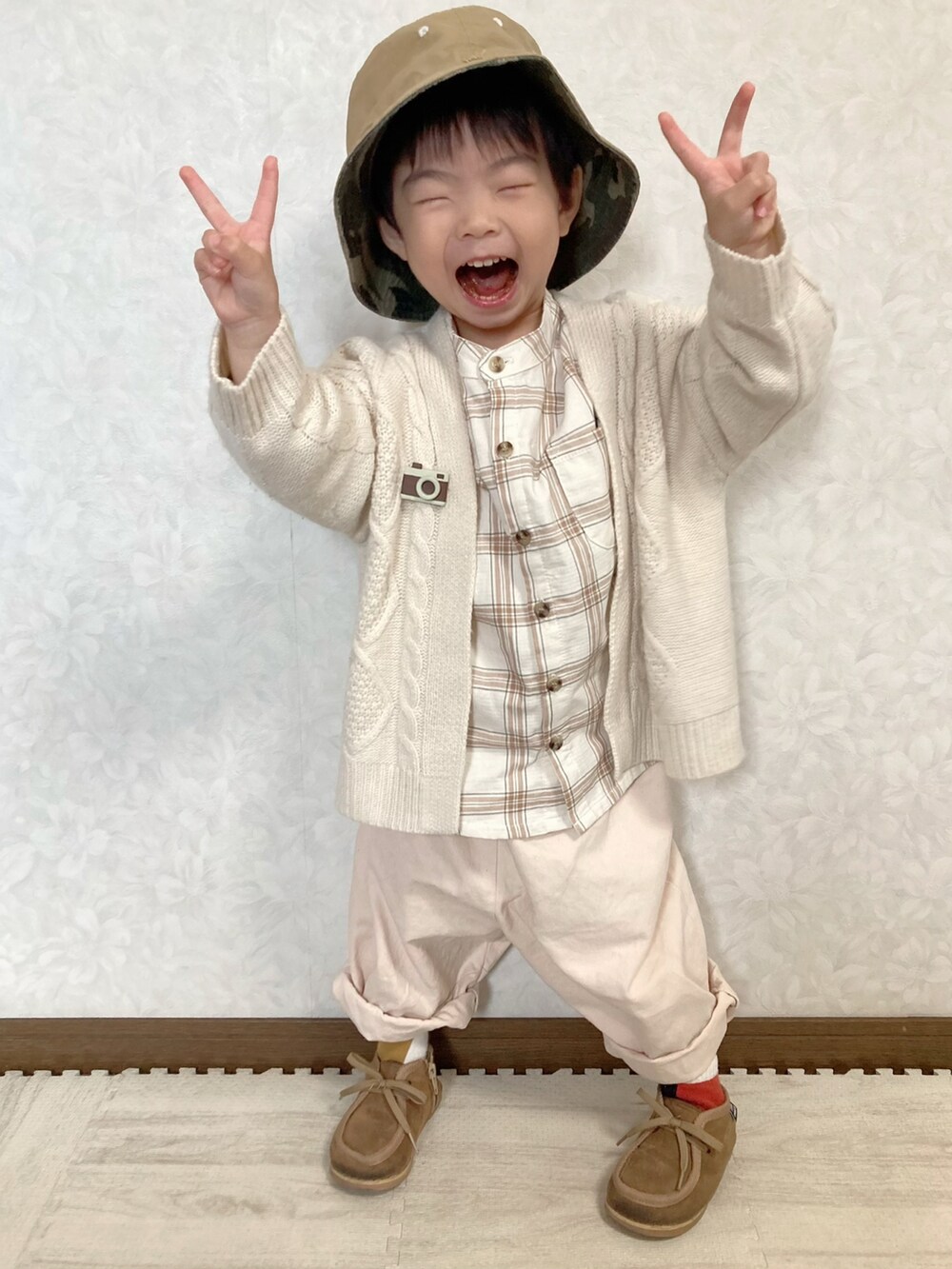 ベージュ系のシャツ/ブラウス、ホワイト系のカーディガン/ボレロ、ベージュ系のチノパンツを着用したキッズの冬コーディネートの2枚目の写真