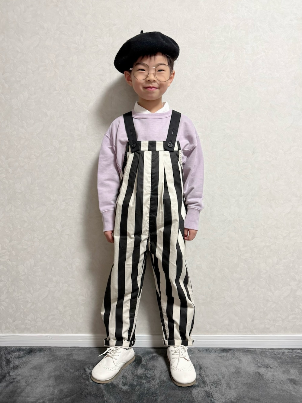 パープル系のスウェット、ブラック系のサロペット/オーバーオール、ホワイト系のシャツ/ブラウスを着用したキッズの冬コーディネートの2枚目の写真