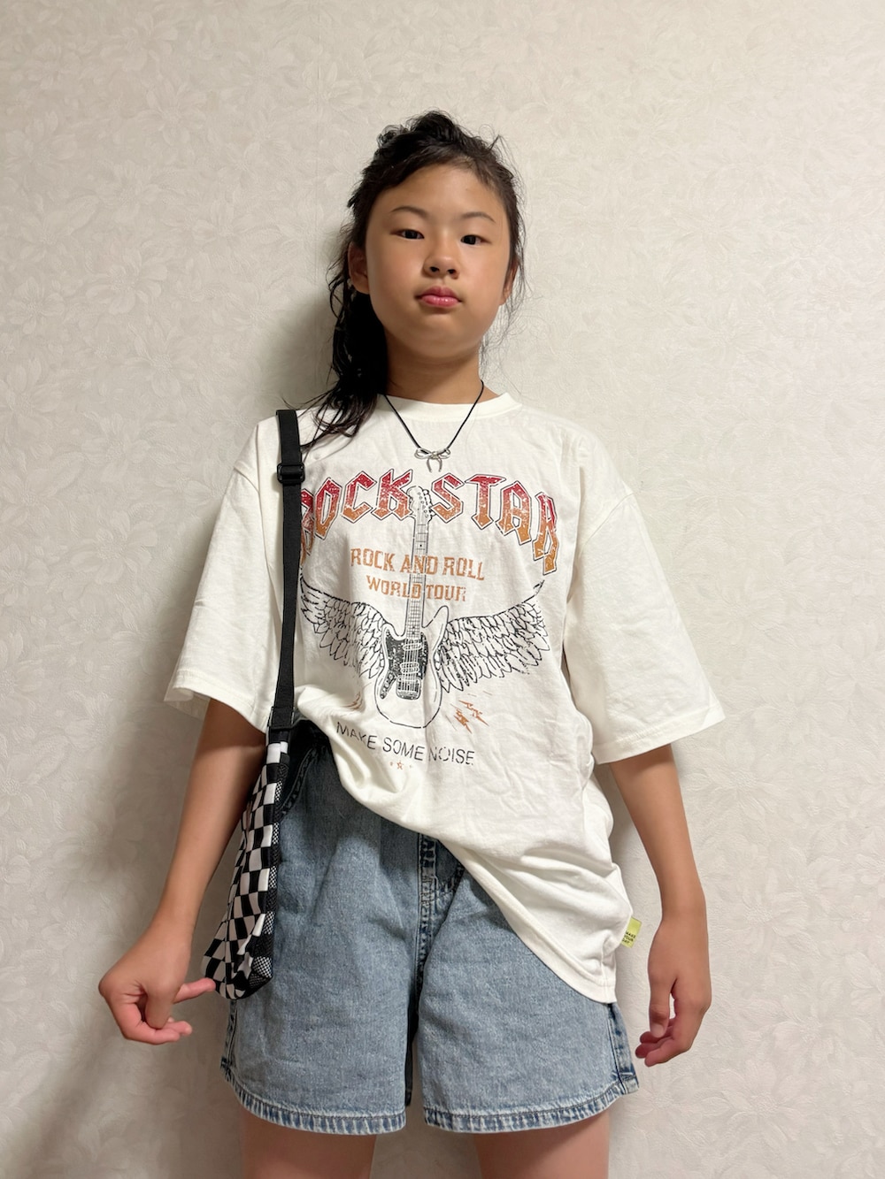 ブラック系のスニーカー、ホワイト系のTシャツ/カットソー、その他のショルダーバッグを着用したキッズの夏コーディネートの2枚目の写真