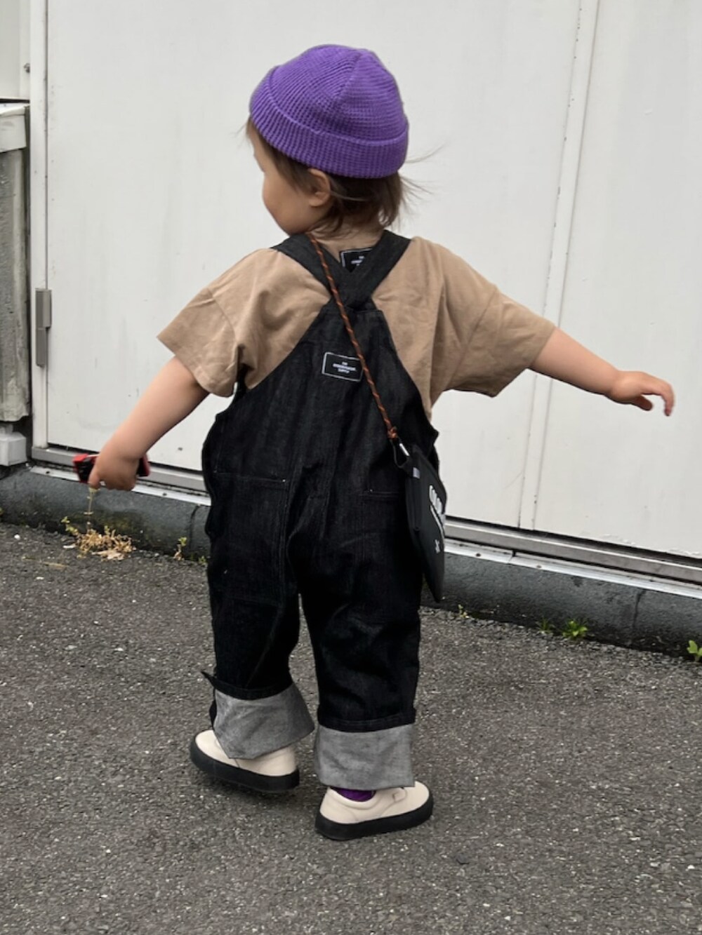 ブラウン系のTシャツ/カットソー、ブルー系のサロペット/オーバーオール、ホワイト系のショルダーバッグを着用したキッズの夏コーディネートの3枚目の写真