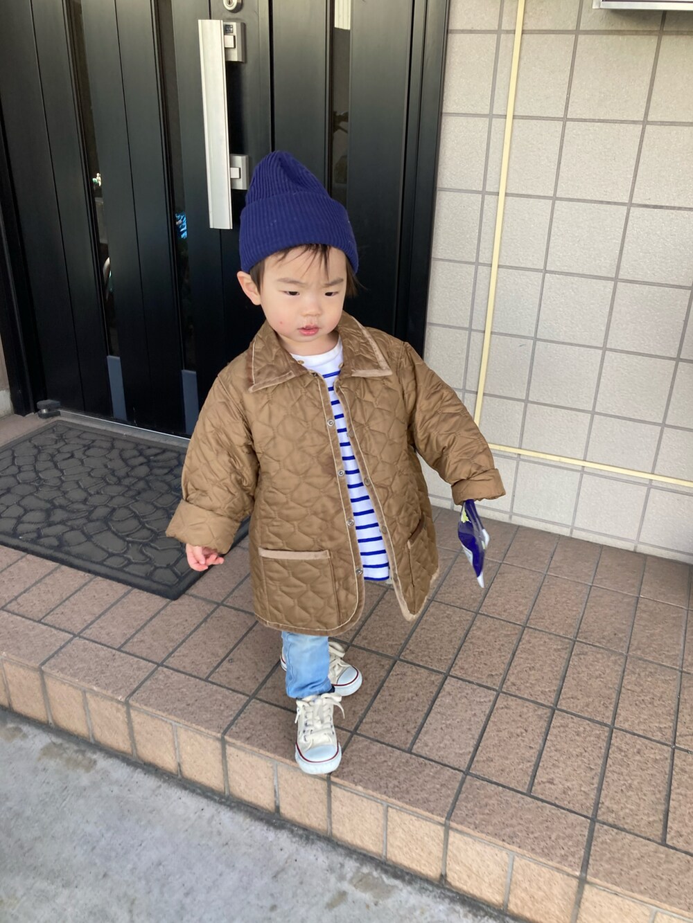 ブルー系のTシャツ/カットソー、ホワイト系のカーディガン/ボレロ、ブルー系のデニムパンツを着用したキッズの冬コーディネートの3枚目の写真