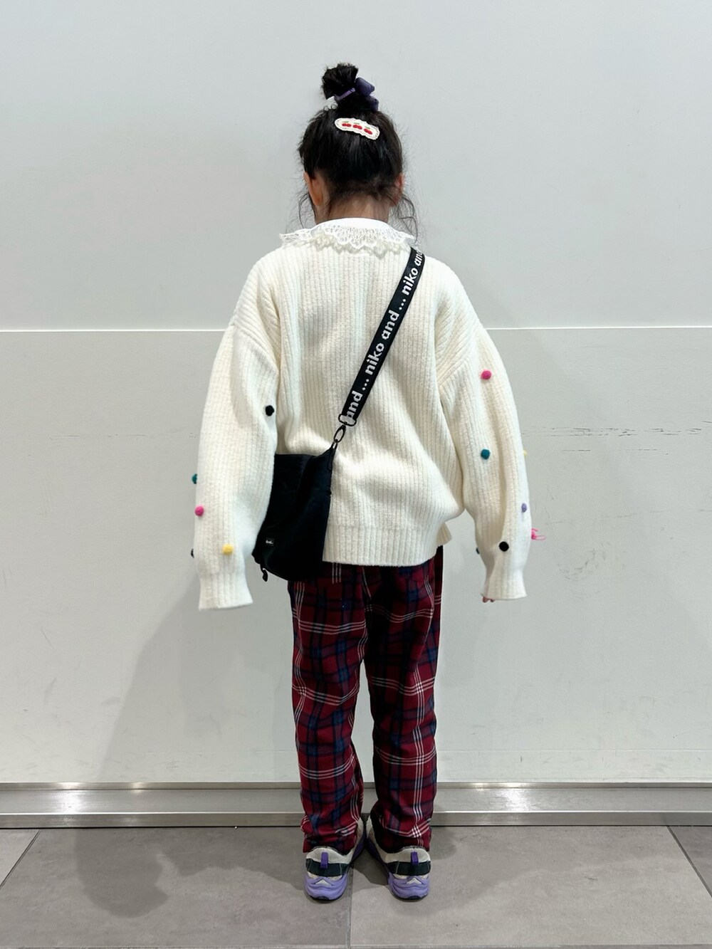 ホワイト系のニット/セーター、ホワイト系のシャツ/ブラウス、ブラック系のショルダーバッグを着用したキッズの冬コーディネートの3枚目の写真