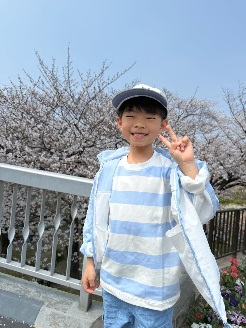 グリーン系のTシャツ/カットソー、ブルー系のナイロンジャケット、ブルー系のパンツを着用したキッズの春コーディネートの4枚目の写真