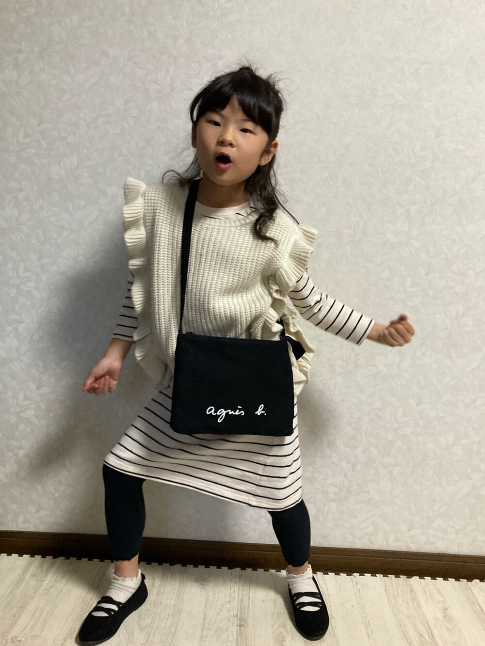 ブラック系のバレエシューズ、ホワイト系のワンピース、ベージュ系のベストを着用したキッズの春コーディネートの3枚目の写真