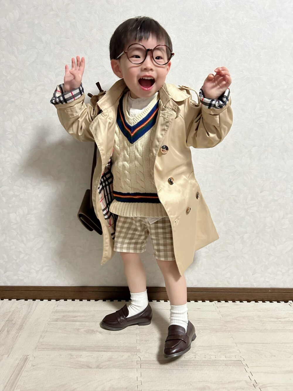 ホワイト系のシャツ/ブラウス、ホワイト系のベスト、ベージュ系のトレンチコートを着用したキッズの春コーディネートの2枚目の写真