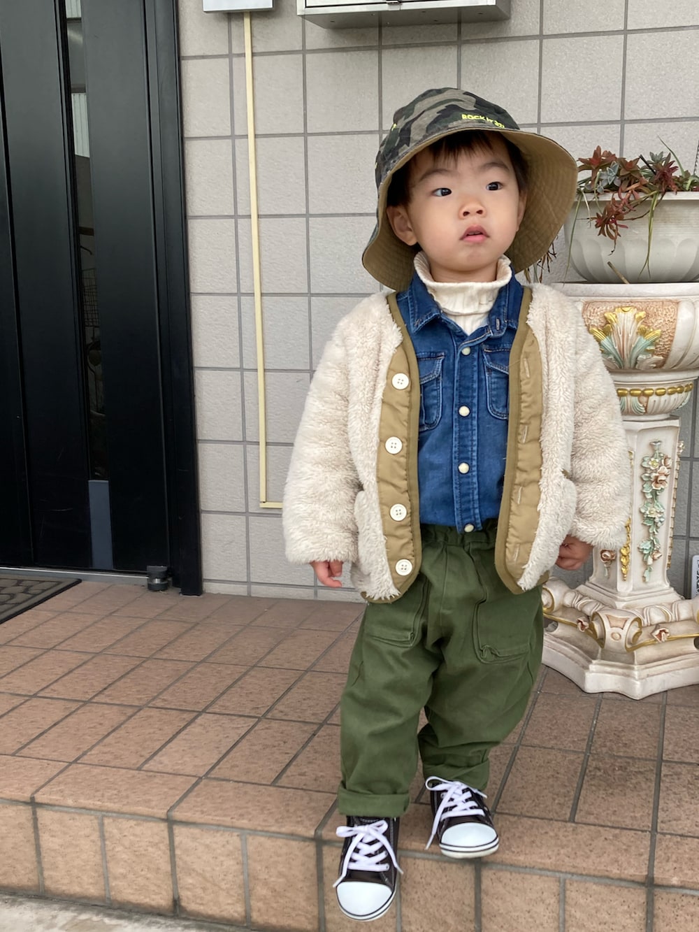 ホワイト系のニット/セーター、ブルー系のシャツ/ブラウス、グリーン系のスカートを着用したキッズの冬コーディネートの4枚目の写真