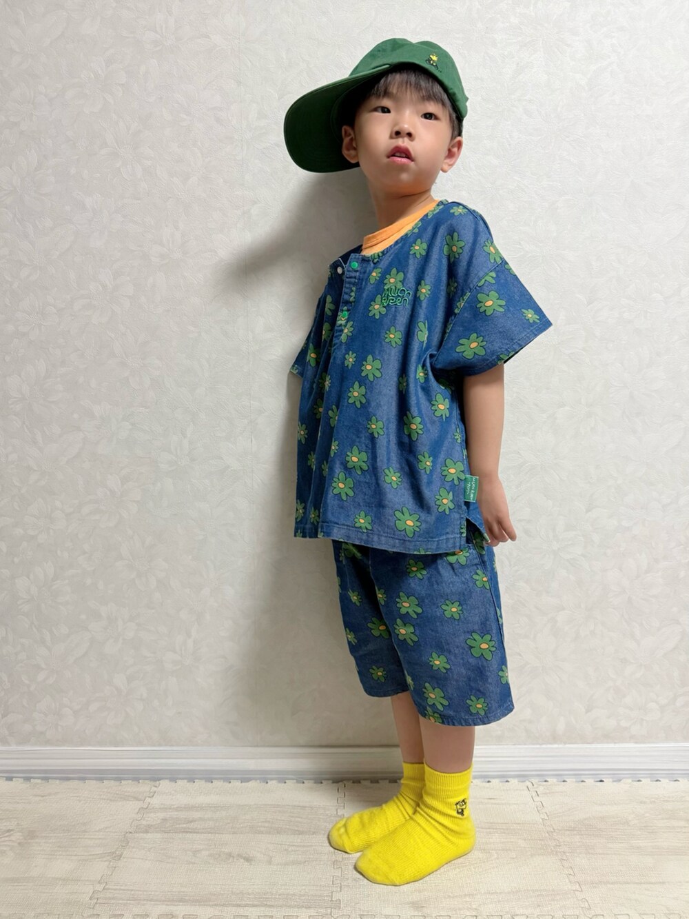 オレンジ系のタンクトップ、ブルー系のスニーカー、ブルー系のセットアップを着用したキッズの夏コーディネートの3枚目の写真