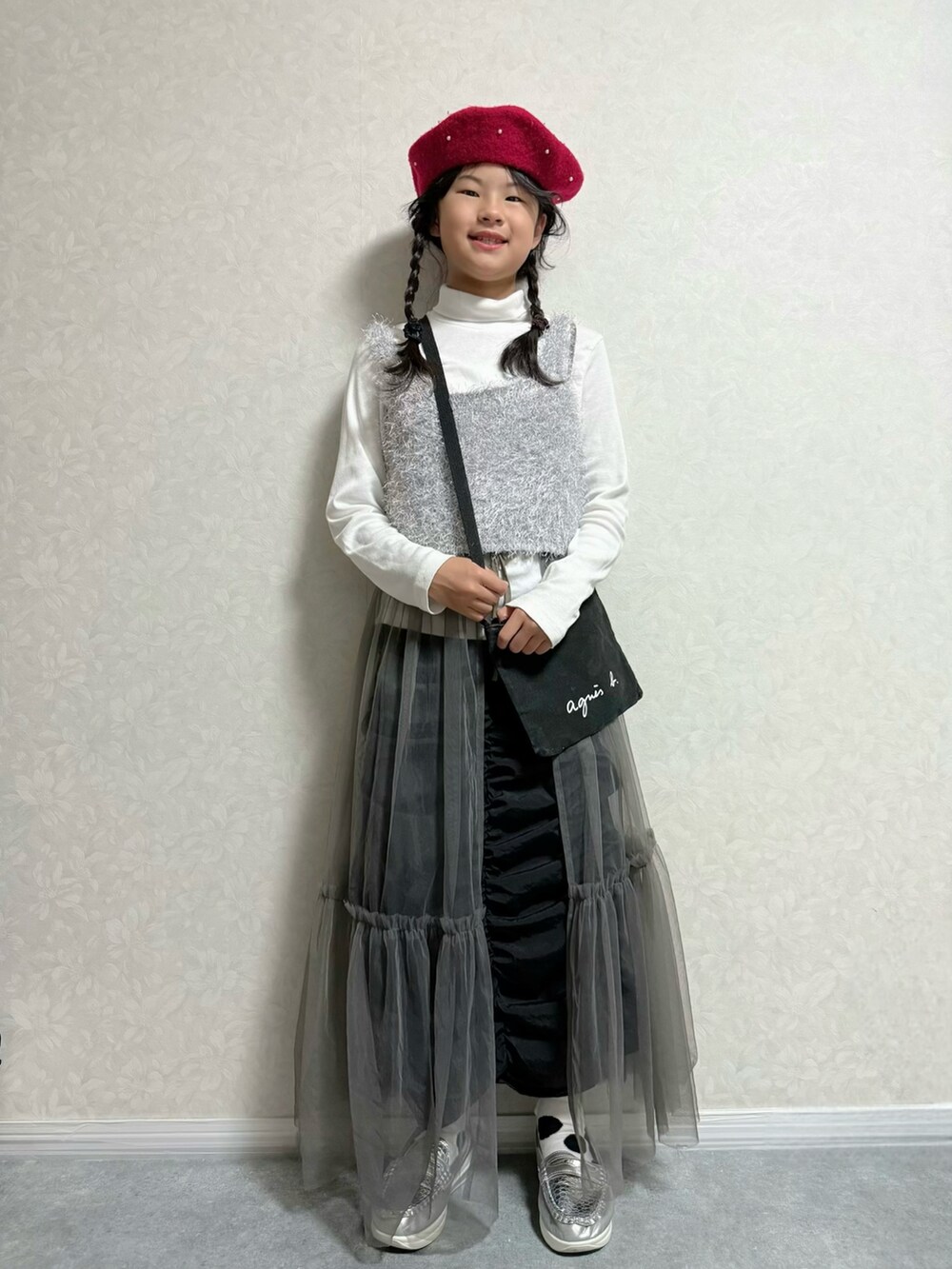 ホワイト系のTシャツ/カットソー、ブラック系のスカート、ブラック系のショルダーバッグを着用したキッズの秋コーディネートの2枚目の写真