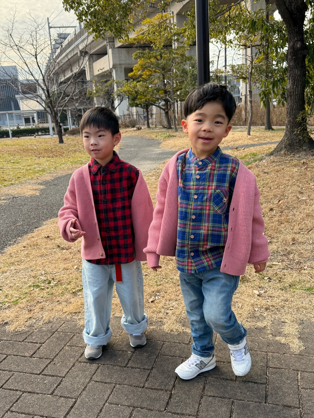 ピンク系のカーディガン/ボレロ、レッド系のシャツ/ブラウス、ブルー系のデニムパンツを着用したキッズの冬コーディネートの3枚目の写真