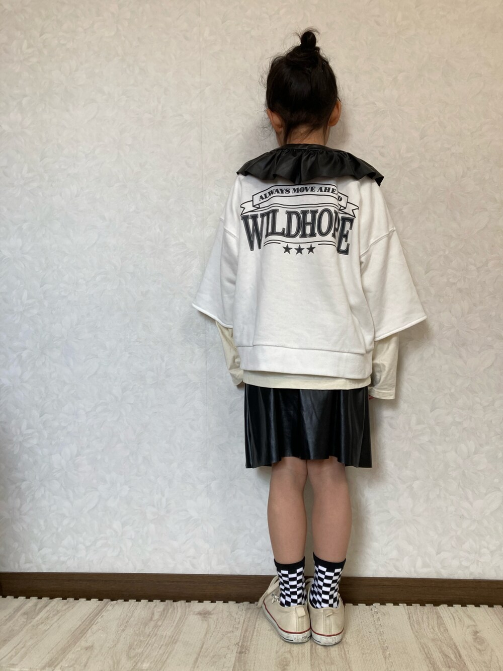 ホワイト系のTシャツ/カットソー、ホワイト系のスウェット、ブラック系のスカートを着用したキッズの冬コーディネートの2枚目の写真