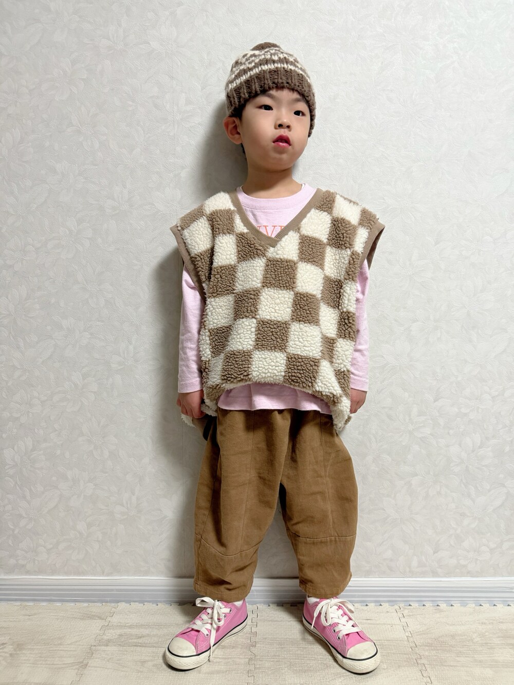 ピンク系のTシャツ/カットソー、ブラウン系のベスト、ブラウン系のショルダーバッグを着用したキッズの冬コーディネートの4枚目の写真