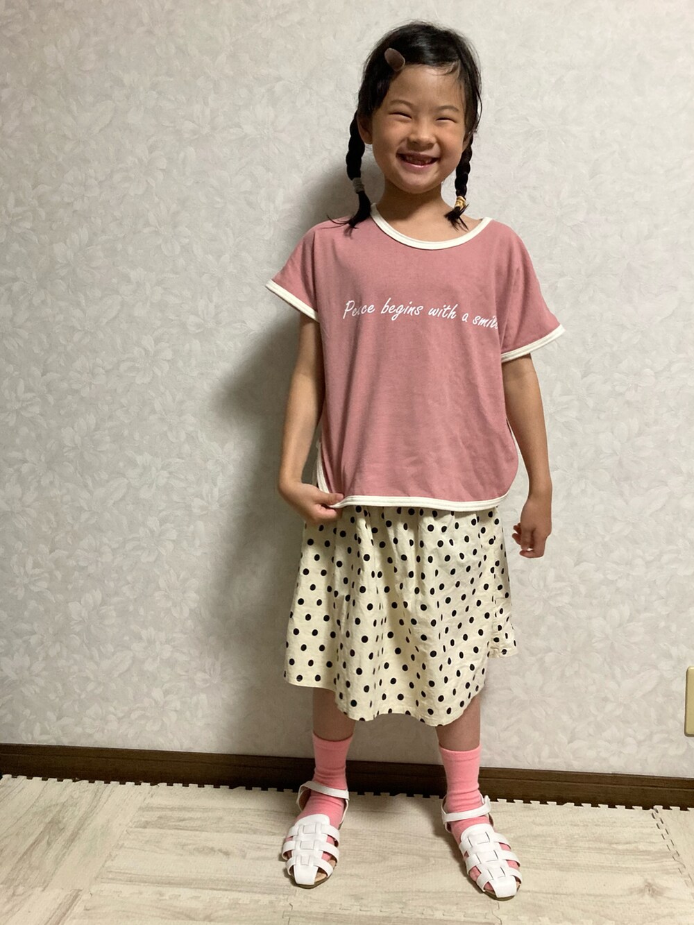 ピンク系のTシャツ/カットソー、ベージュ系のトレンチコート、ホワイト系のショルダーバッグを着用したキッズの春コーディネートの5枚目の写真