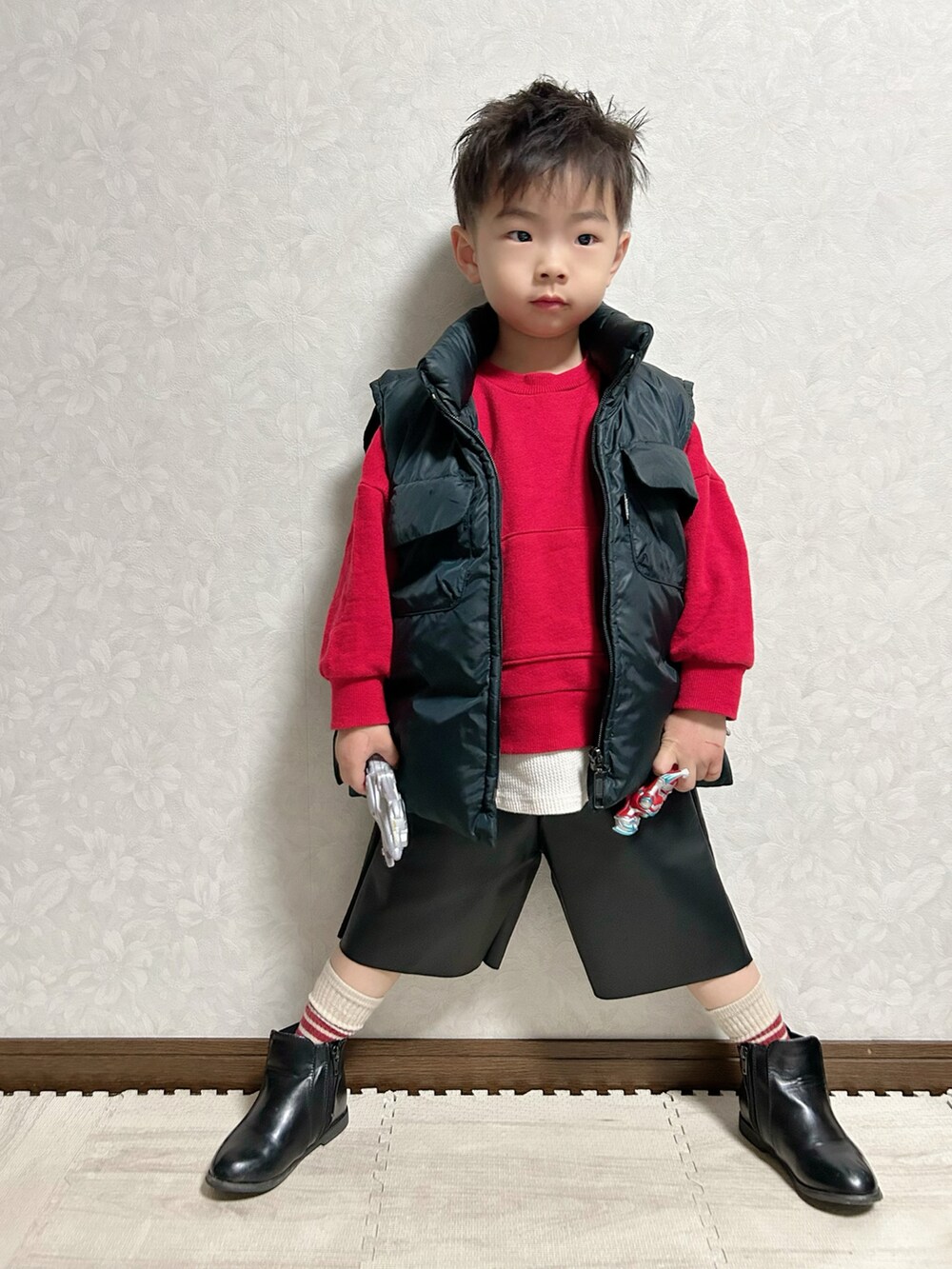 ブラック系のパンツ、レッド系のスウェット、ブラック系のブーツを着用したキッズの冬コーディネートの3枚目の写真