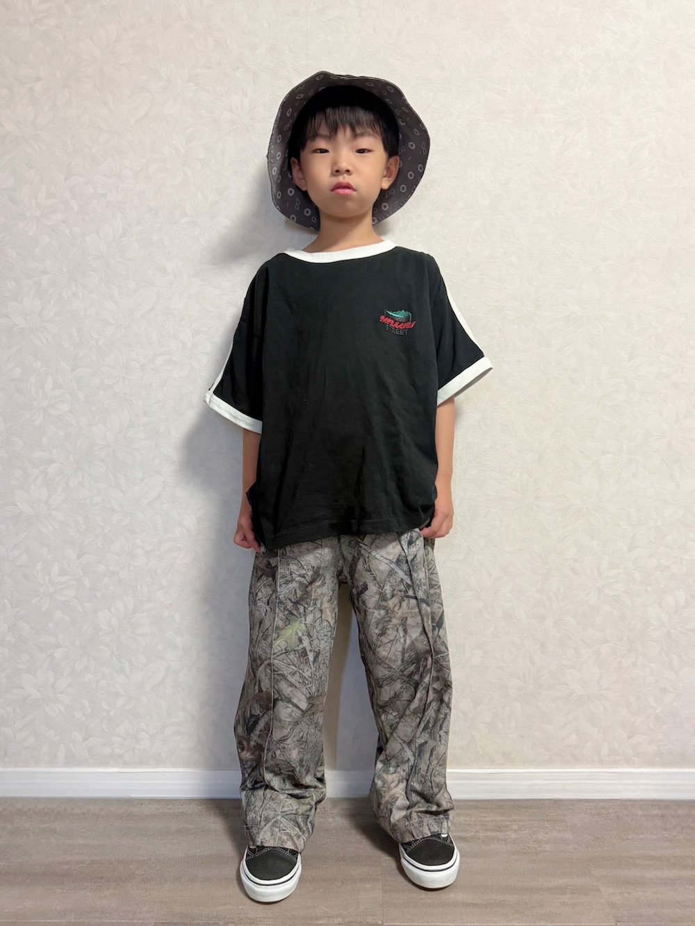 ブラック系のセットアップ、ベージュ系のその他パンツ、ブラック系のスニーカーを着用したキッズの夏コーディネートの2枚目の写真