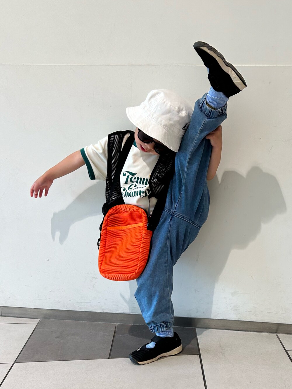 ホワイト系のTシャツ/カットソー、ブラック系のベスト、ブルー系のデニムパンツを着用したキッズの春コーディネートの4枚目の写真